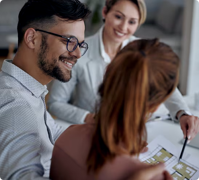 Illustrative photograph of a couple reviewing plans with a consultant.
